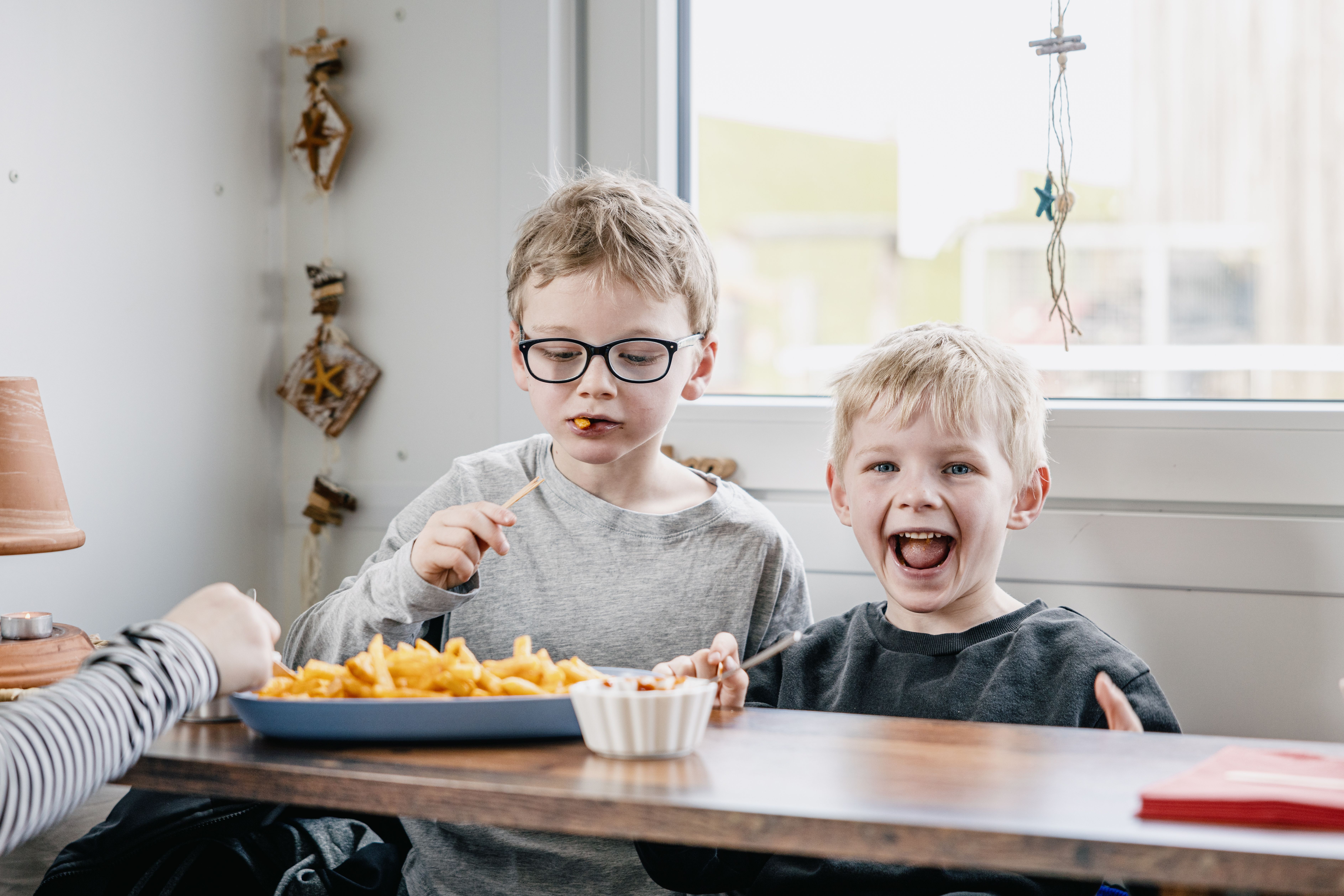 Zwei Jungs essen Pommes auf Nordstrand