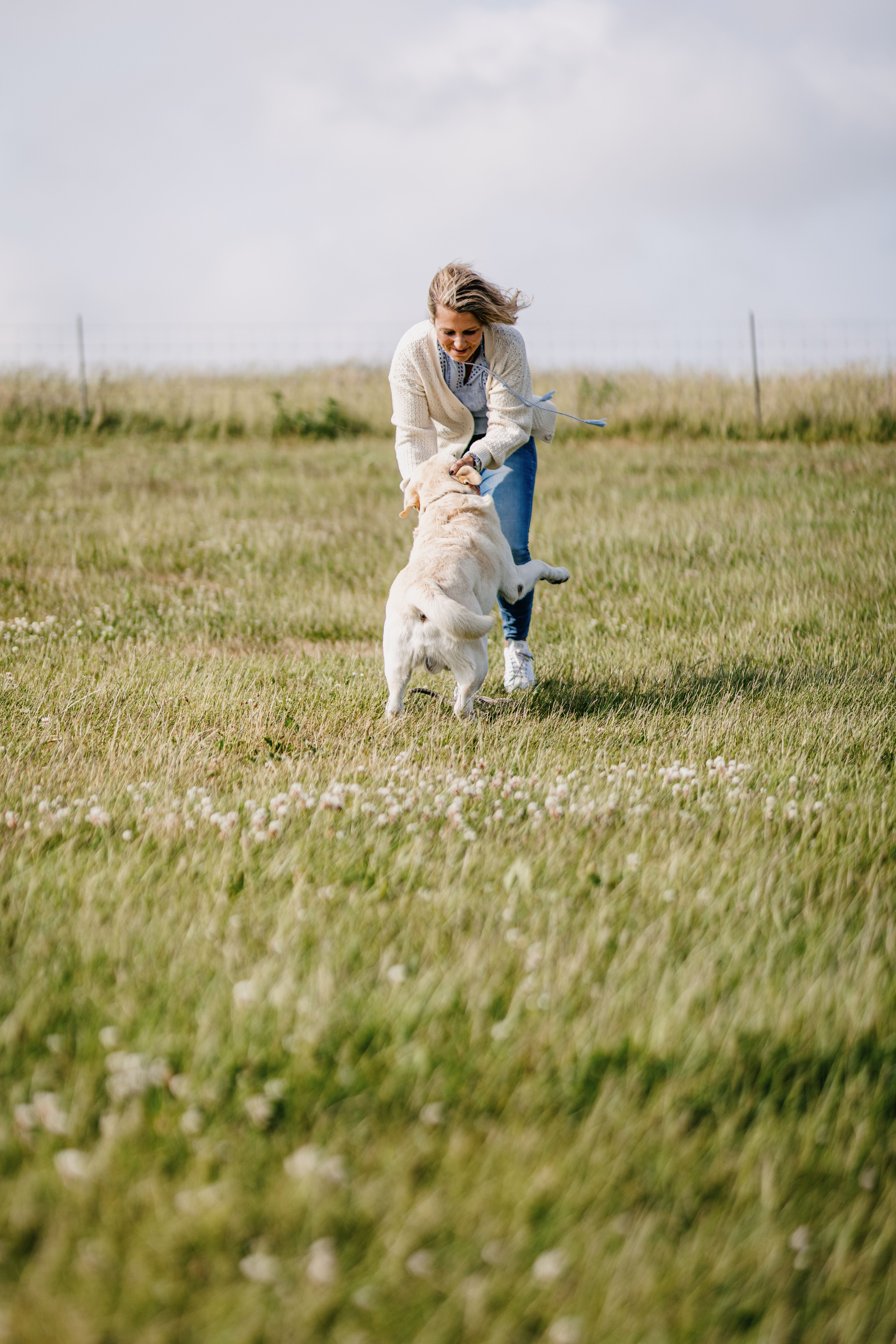 Frau mit Hund am Spielen auf Nordstrand